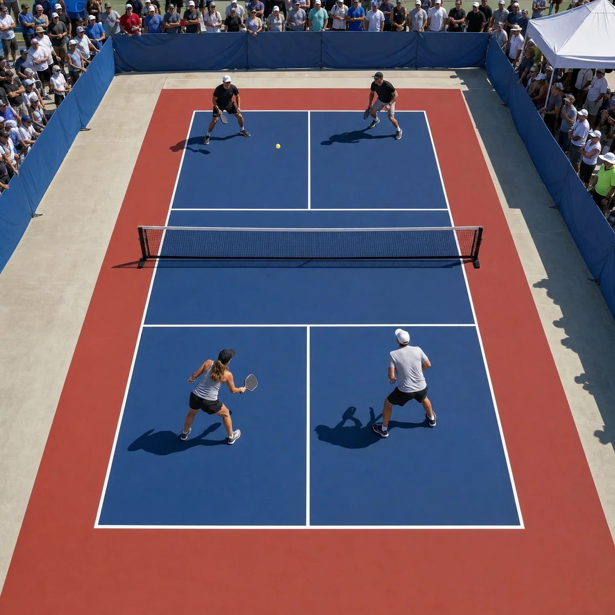 Pista de pickleball portátil de alquiler durante un torneo de fin de semana con vallas y público