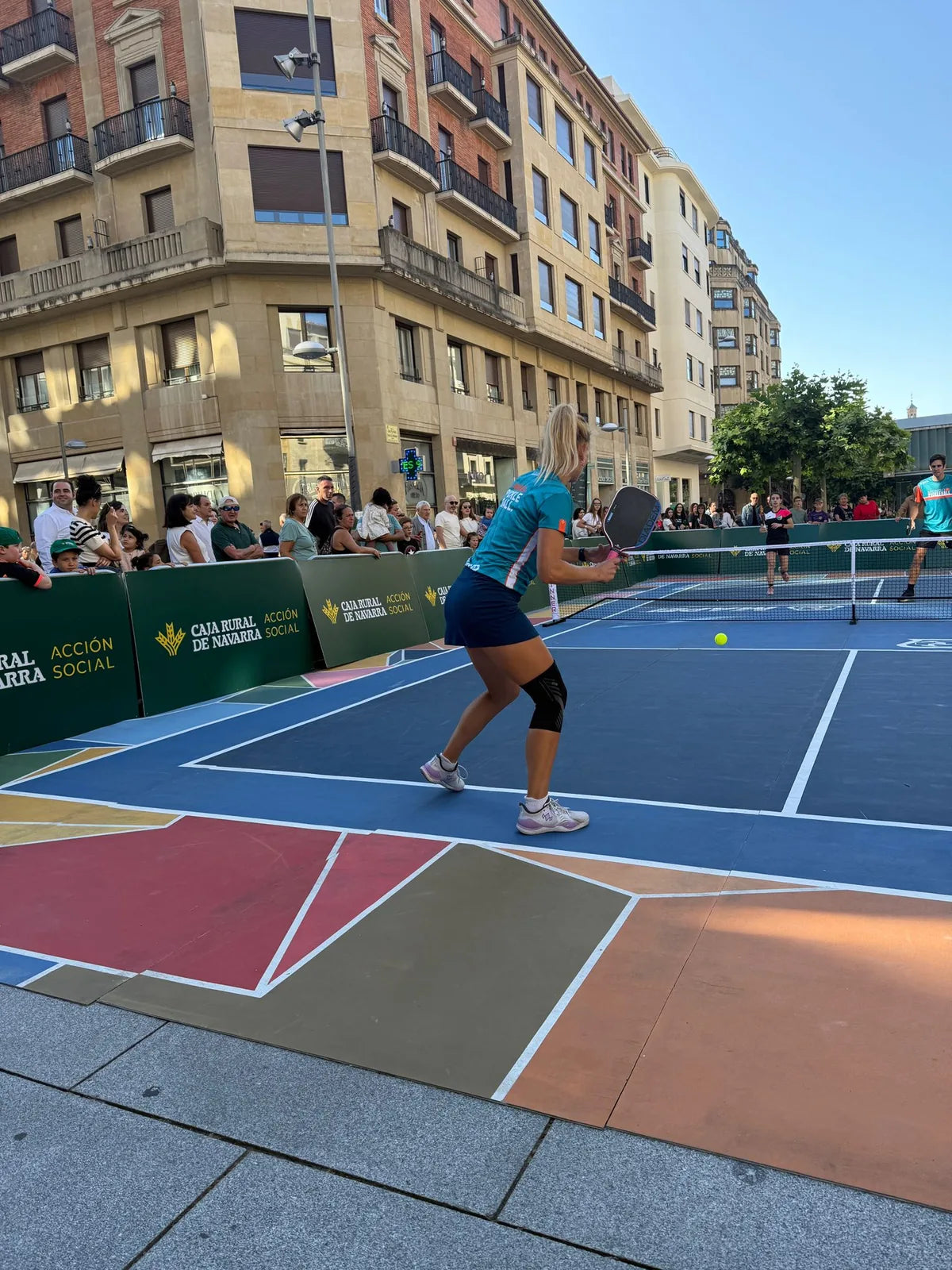 Partido de pickleball en pista portatil instalada en una calle del centro de Pamplona con publico siguiendo el juego