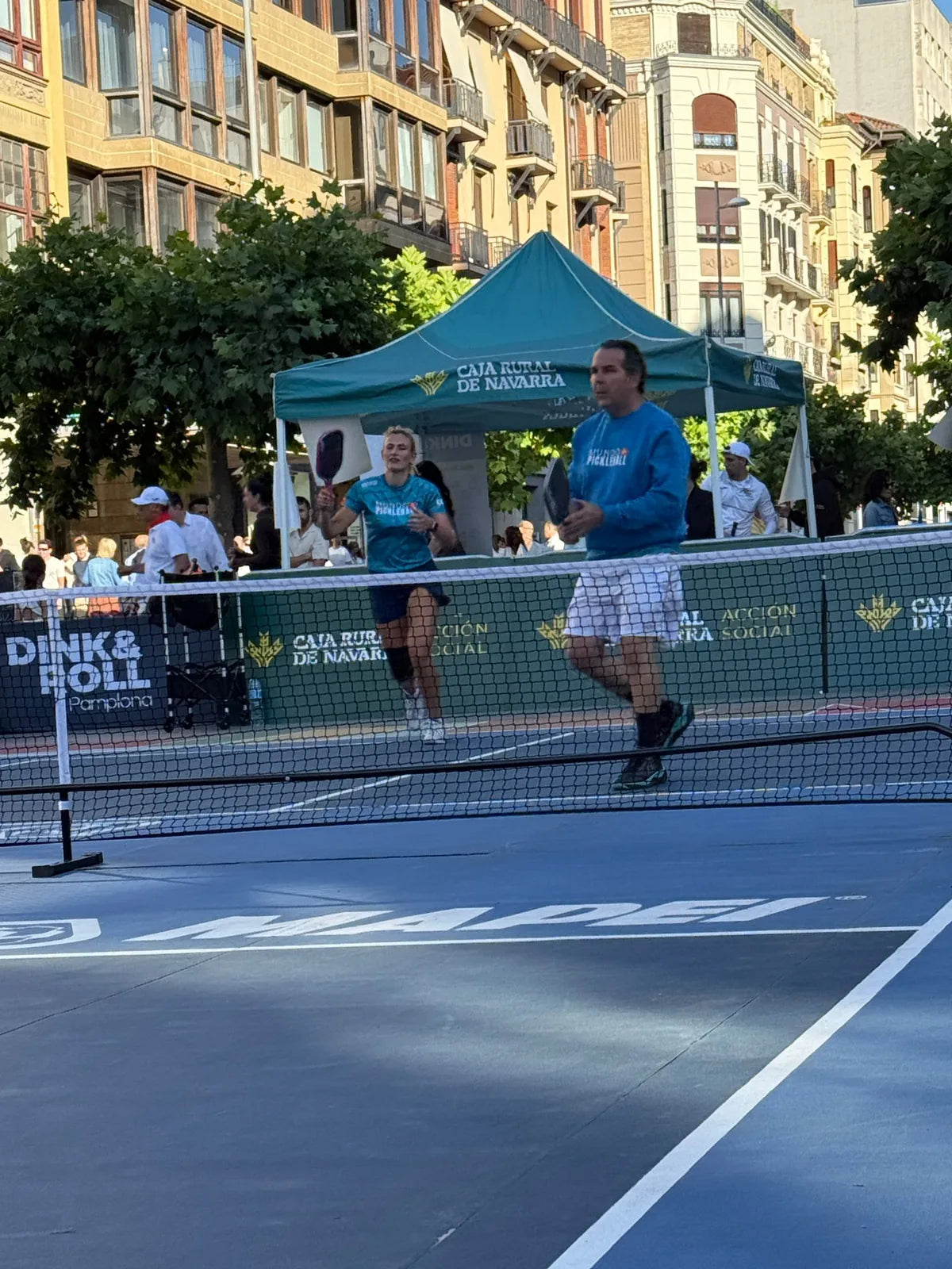 Jugadores en accion durante el torneo Dink & Roll de Pamplona sobre pista portatil con perimetral de patrocinador